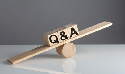 Q and A on wooden cubes on wooden balance , business concept