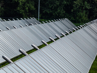 PV solar panels from solar field providing alternative green energy used for heating. Solar thermal collectors generating electricity, use of renewable energy