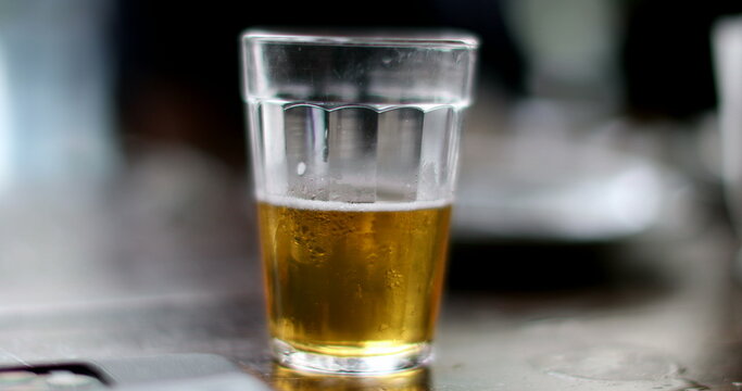 Beer Glass On Table At Bar. Half Empty Or Half Full Beer Glass