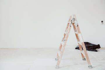 ladders and painter tools on white room at construction site. Painting walls. Home improvement