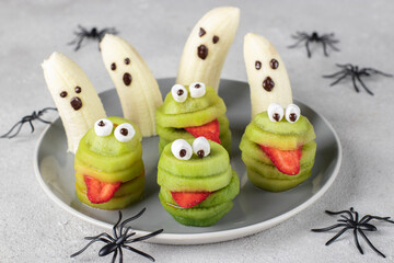 Spooky banana ghosts monsters and green kiwi monsters for Halloween party. Halloween Fruit Serving Idea