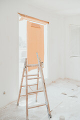 ladder on white room at construction site. Painting walls. Home improvement, renovation © Eva
