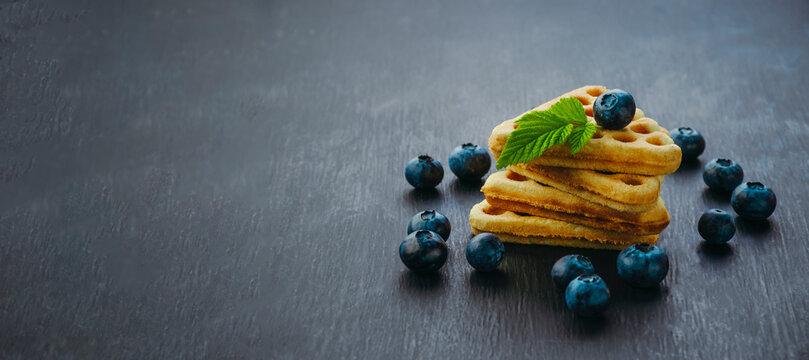  Fresh waffles with blueberries. Breakfast. Dark Background. Healthy food concept. Organic blueberries.