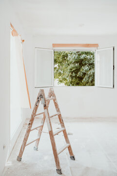 ladders and painter tools on white room at construction site. Painting walls. Home improvement