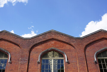 roof and wall of old hanger building. large structure under bright blue sky. copy space. 