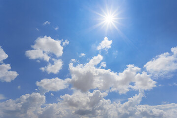 Naklejka na ściany i meble hot sparkle sun on blue cloudy sky background