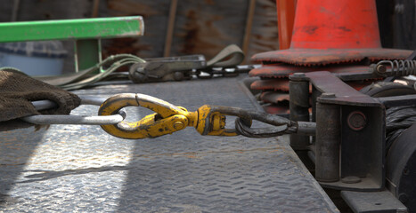 Connection of a tow truck winch to the cable attached to an automobile.