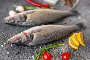 raw sea bass fish on stone background