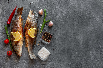 Baked sea bass fish on stone background with copy space for your text - obrazy, fototapety, plakaty