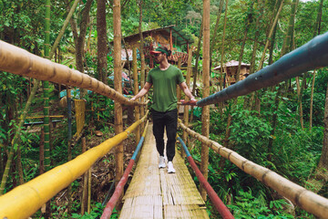 Naklejka na ściany i meble man crossing bridge in forest