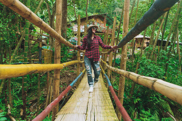 girl crossing bridge in forest