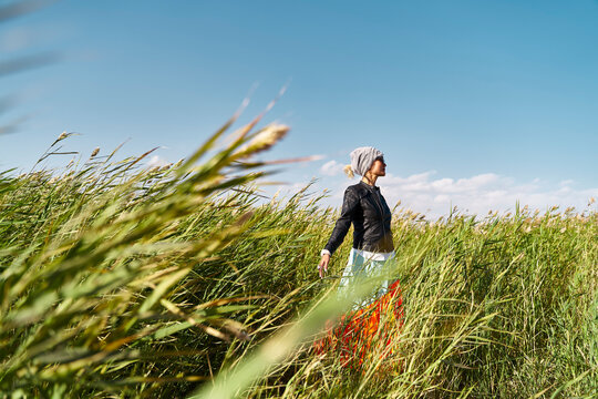 asian woman standing in the milddle of a reed marsh