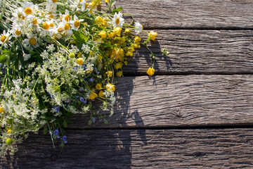Summer bouquet of wildflowers on old wooden board background. Midsummer flowers. Top view, copy...