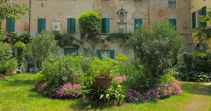 Typical Green Courtyard Garden Landscape On A Sunny Day In Northern Italy. - Pan Right Shot