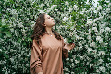 beautiful girl in blooming apple tree aroma of flowers outdoor nature