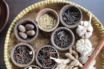 Blurry A view of the mixture of spices, herbs and cooking ingredients in the rattan pan.