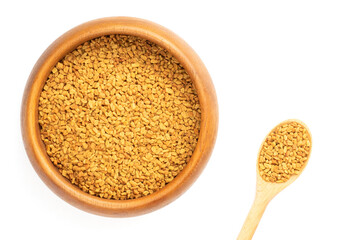 Fenugreek (Trigonella foenum-graecum) in wooden bowl and spoon on white background isolated. Macro. Flat lay. Indian cuisine, ayurveda, naturopathy concept