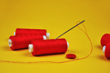 Red threads Spools on a yellow background.