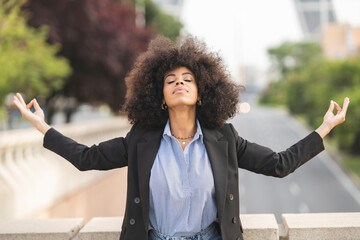 afro american business woman with curly hair relaxing meditating outdoors