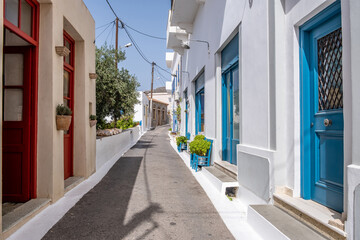 Fototapeta na wymiar Greece, Kythira island. Empty narrow street at Chora town. Traditional white color wall building