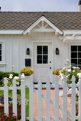 charming white beach cottage with vintage gate and flowers