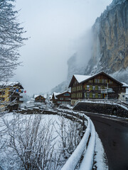 Lauterbrunnen village main street and waterfall after snowfall in Switzerland