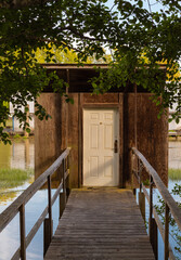 Old wooden boathouse at a lake. Wooden cabin with pier on the river.