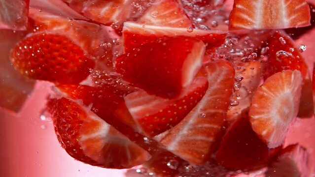 Super Slow Motion Shot of Fresh Strawberries Falling into Water Vortex at 1000 fps.