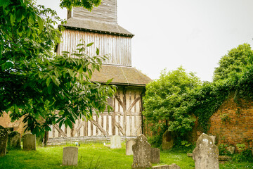 Aged look to a rare wooden bell tower seen in a rural church and cemetery. The fine timber work can...
