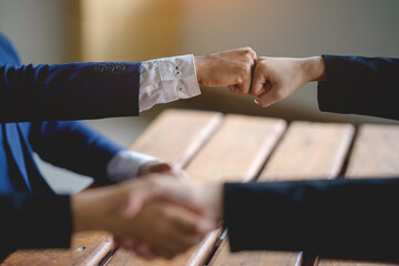The hands of a group of businessmen shake hands to reach an agreement in a company meeting.