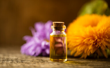 oils with flowers. Oil bottle. Flowers. Wooden table. Photo. Background. Bottle. Aroma.