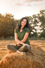 Fototapeta na wymiar woman is sitting on a haystack