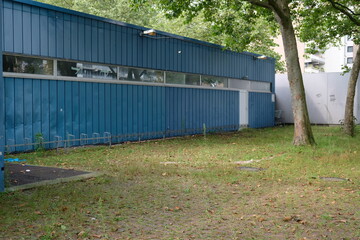 Fototapeta na wymiar FU 2021-08-22 Blumen 84 Vor dem blauen Gebäude ist eine Wiese mit Fahrradständern