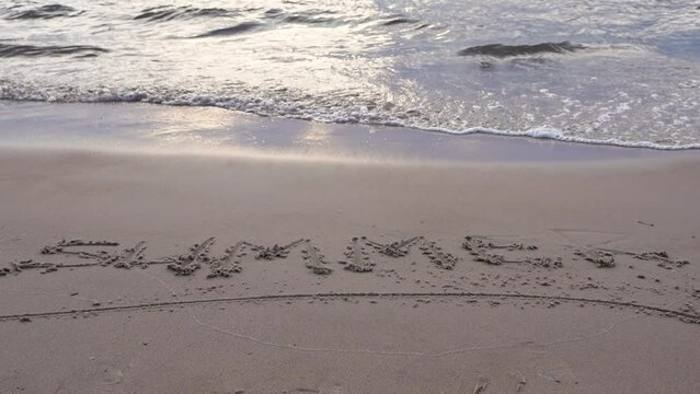 the word summer is written on the sand on the sea sandy beach.