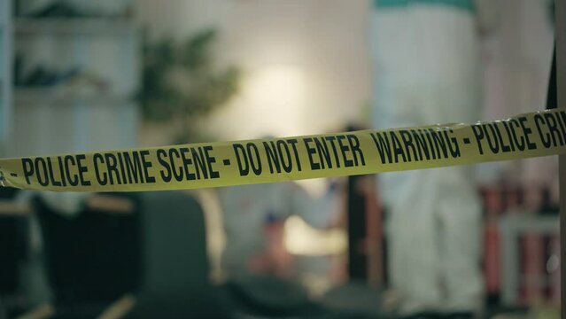 Crime scene tape close-up, forensic experts examining room, collecting evidence