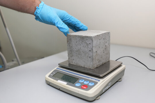 Modern laboratory for testing road samples and materials concept. A sample of cement concrete on an electronic scale.