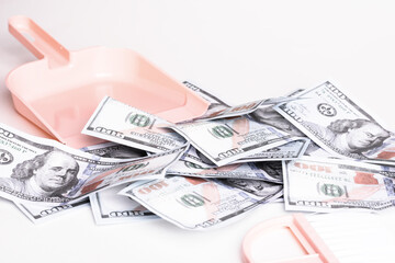 Dustpan, hand brooms and crumpled money dollar bills. Money as garbage. Financial crisis, corruption, criminal activity concept.