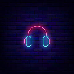 Headphones neon icon. Music store. Shiny sign on brick wall. Glowing effect emblem. Vector stock illustration