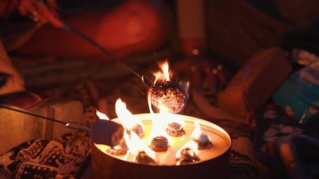 Young Woman Burning A Marshmallow She Is Roasting And Blowing On It Using Small Flame At Dusk.