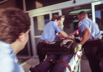 Paramedics rushing patient with cardiac arrest in to the hospital emergency entrance.