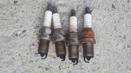 Used car spark plugs. 4 pieces. Black tips. Car repair. Replacement of consumables. Tech service. Rust. Modern detail.