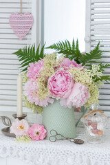romantischer Blumenstrauß mit rosa Pfingstrosen und Holunderblüten in vintage Vase