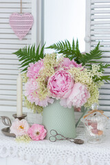 romantischer Blumenstrauß mit rosa Pfingstrosen und Holunderblüten in vintage Vase