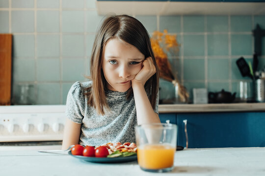 A girl has breakfast in the kitchen
