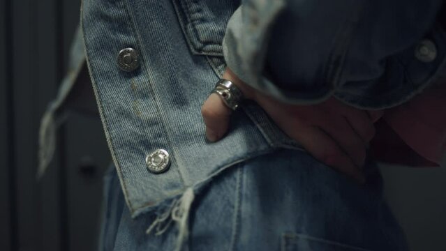 Closeup girl hand wearing ring on hips. Teen schoolgirl pose in blue jeans.
