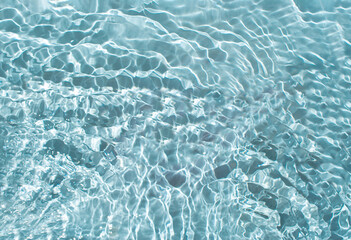 Abstract view of clear water with waves and sun reflection. Shiny blue water with sunlight surface...