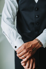 Man putting on cufflinks 