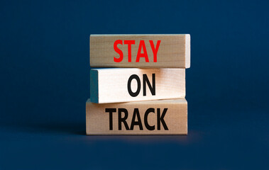 Stay on track symbol. Concept words Stay on track on wooden blocks on a beautiful grey table grey background. Business, motivational and stay on track concept. Copy space.