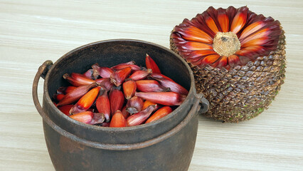 Black iron pot with pine nuts inside and a ball of pine nuts on the side. Wooden background....