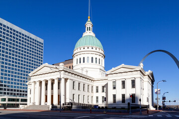 Obraz premium St. Louis, Missouri, USA - March 25, 2022: Basilica of Saint Louis, King of France church with gateway arch in background in St. Louis, Missouri, USA. 